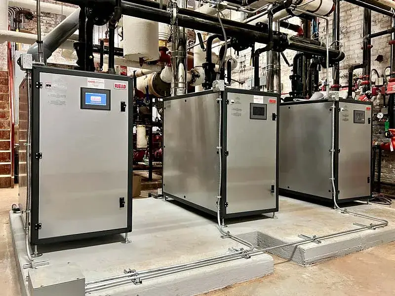 Three industrial machines surrounded by pipes in a commercial HVAC setting, located in Omaha, NE.