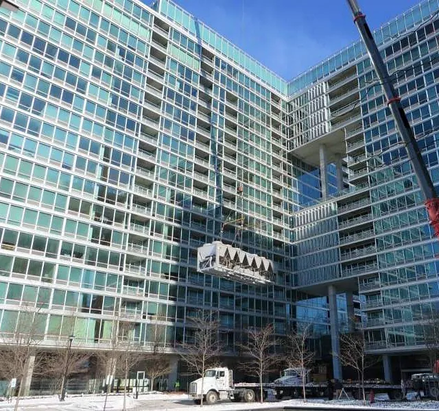A crane is lifting a large block in snowy weather in Chicago, IL